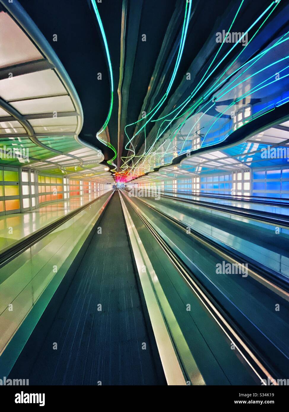 Aéroport international O’Hare. Tunnel entre les concours B et C du terminal Uni avec lumières fluo colorées mobiles et passerelle mobile. Banque D'Images