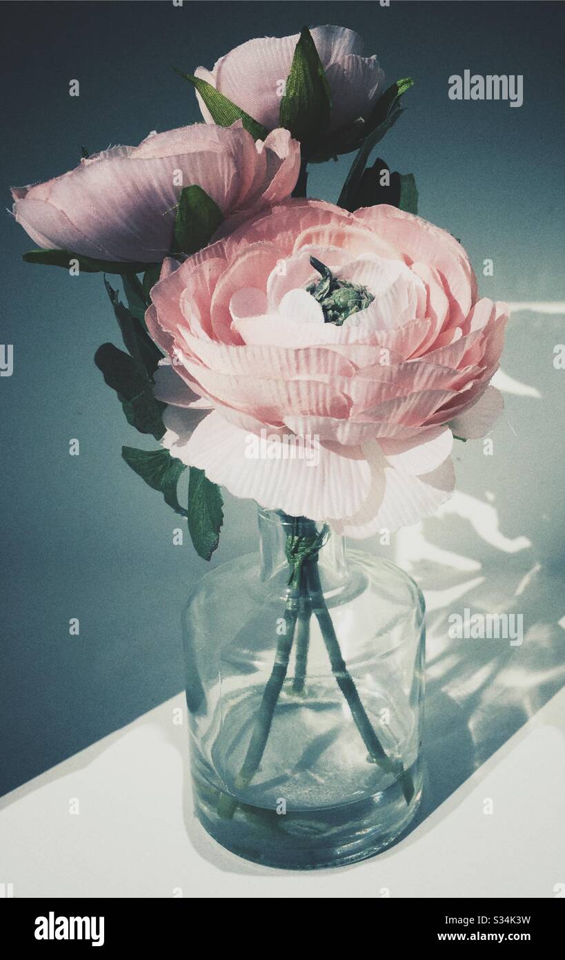Fleurs artificielles en soie dans un vase en verre Banque D'Images