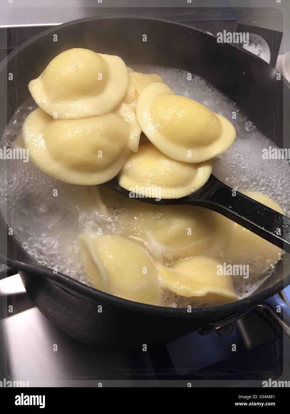 Pâtes raviolis fraîches bouillantes sur un brûleur de poêle résidentiel Banque D'Images