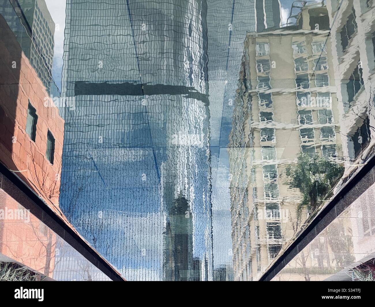 LOS ANGELES, CA, MARS 2020: Détail des réflexions dans la piscine, montrant des immeubles d'appartements et de bureaux colorés à côté de California Plaza dans le centre-ville - Image de stock capturée avec un smartphone