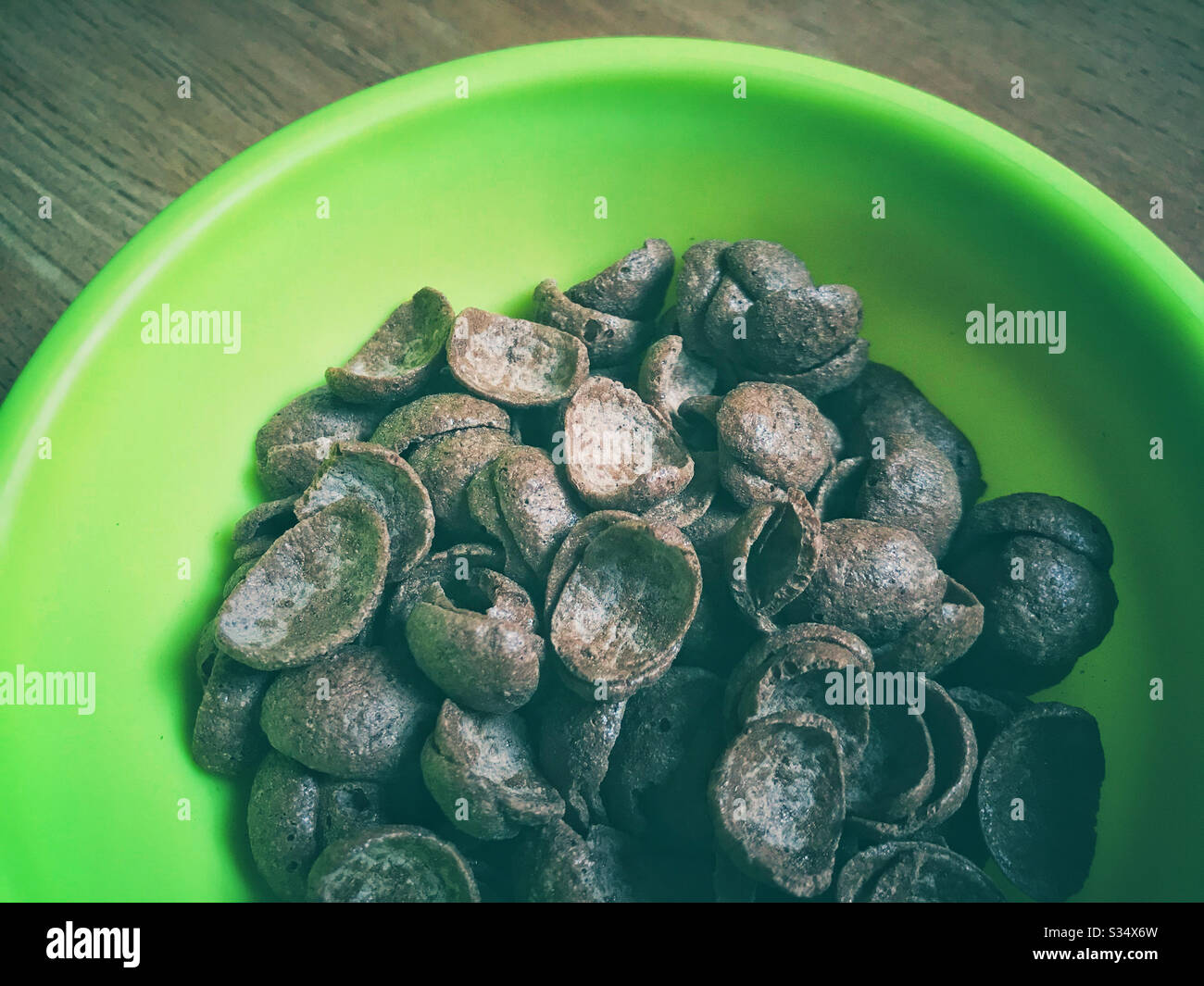 Céréales au chocolat dans un bol en plastique vert. Banque D'Images