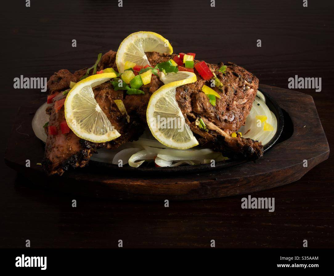 Plaque de poulet tikka sur une table en bois sombre Banque D'Images