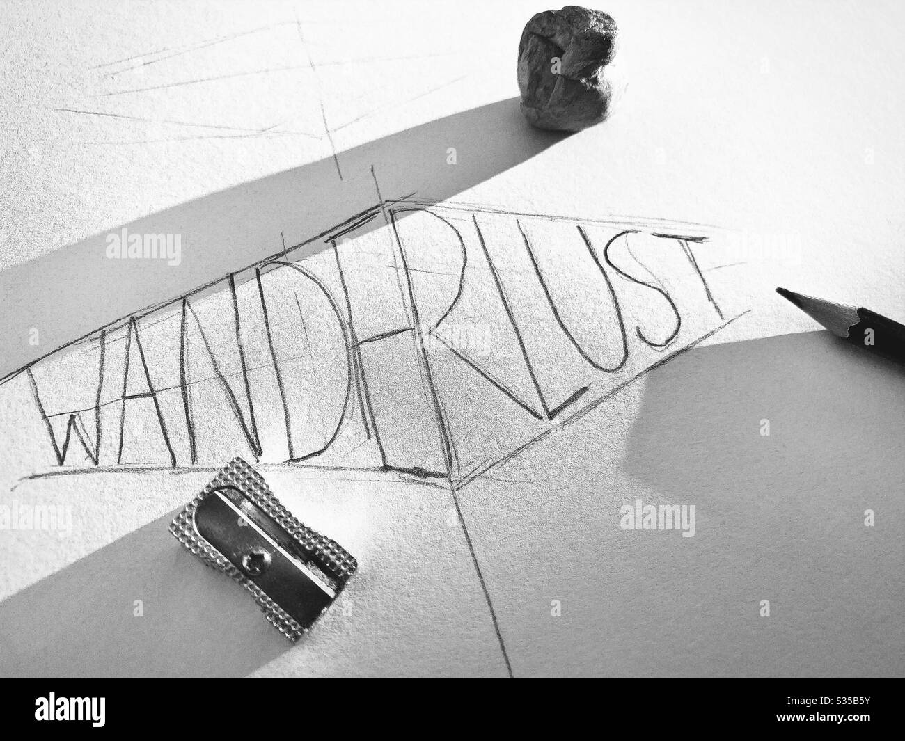 Vue rapprochée de mon carnet d'esquisses. Pratique du lettrage et de la typographie au cours d'une session d'étude de conception graphique. Esquisse et mise en plan. Concept Wanderlust. Croquis rugueux sur papier avec crayon et gomme - Image de stock capturée avec un smartphone