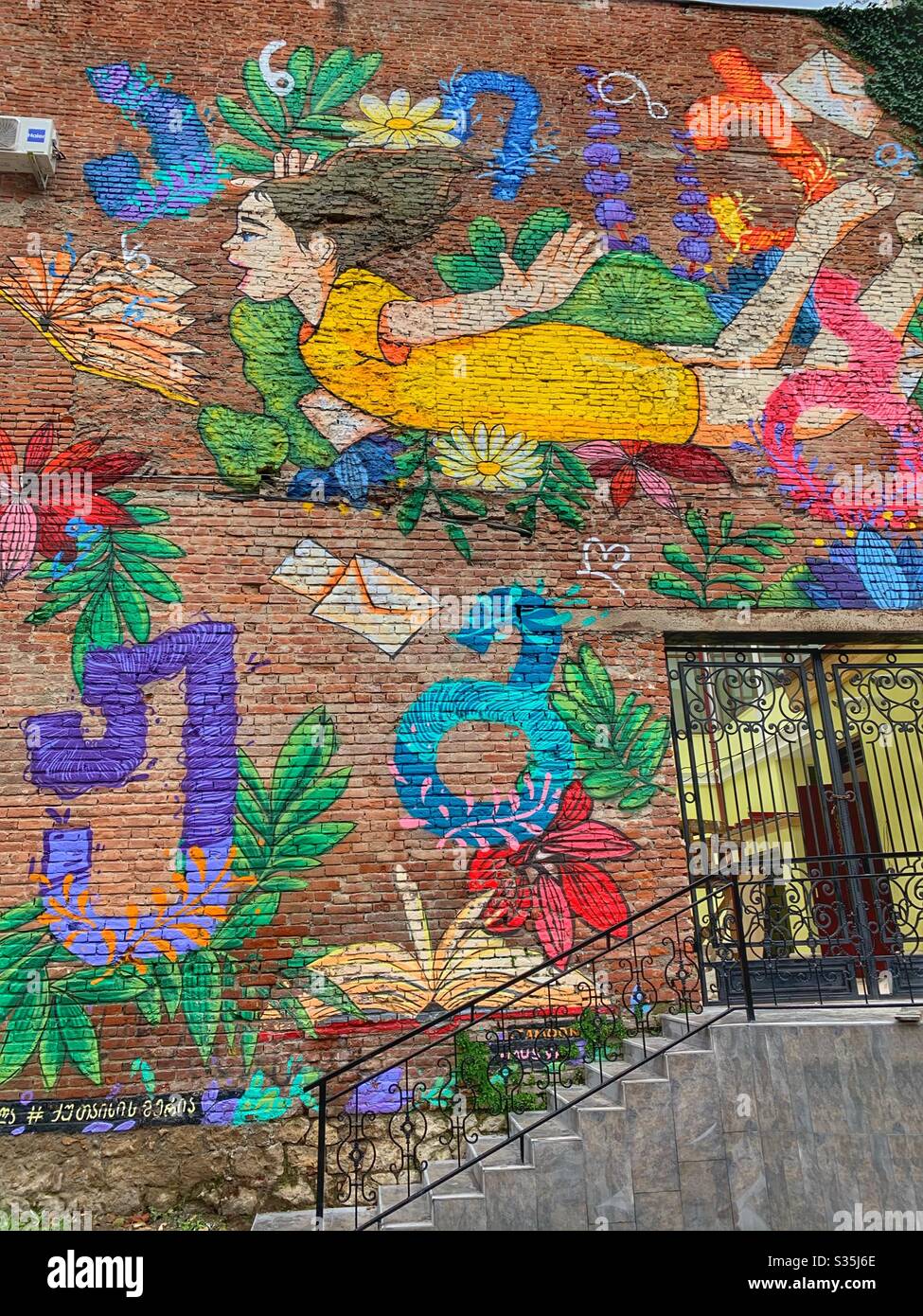 Street art d'une fille volant. Coloriée, un mur en brique à Kutaisi, Géorgie. - Image de stock capturée avec un smartphone