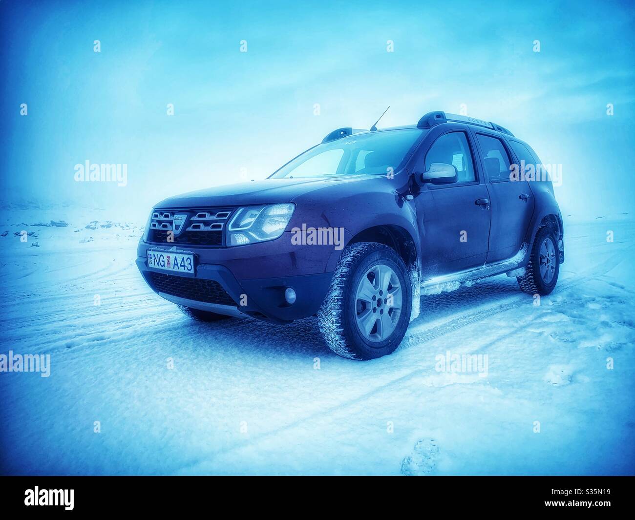 Dacia Duster 4 x 4 voiture de location dans un paysage blanc, Islande. Banque D'Images