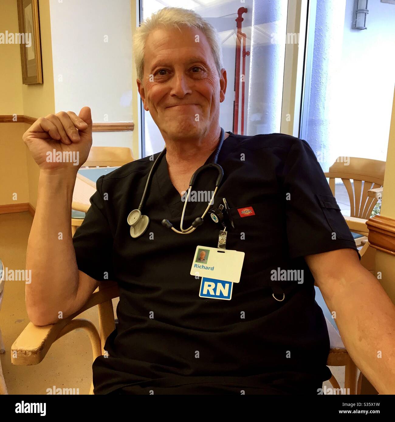 Homme RN assis dans une salle de repos d'hôpital. Banque D'Images