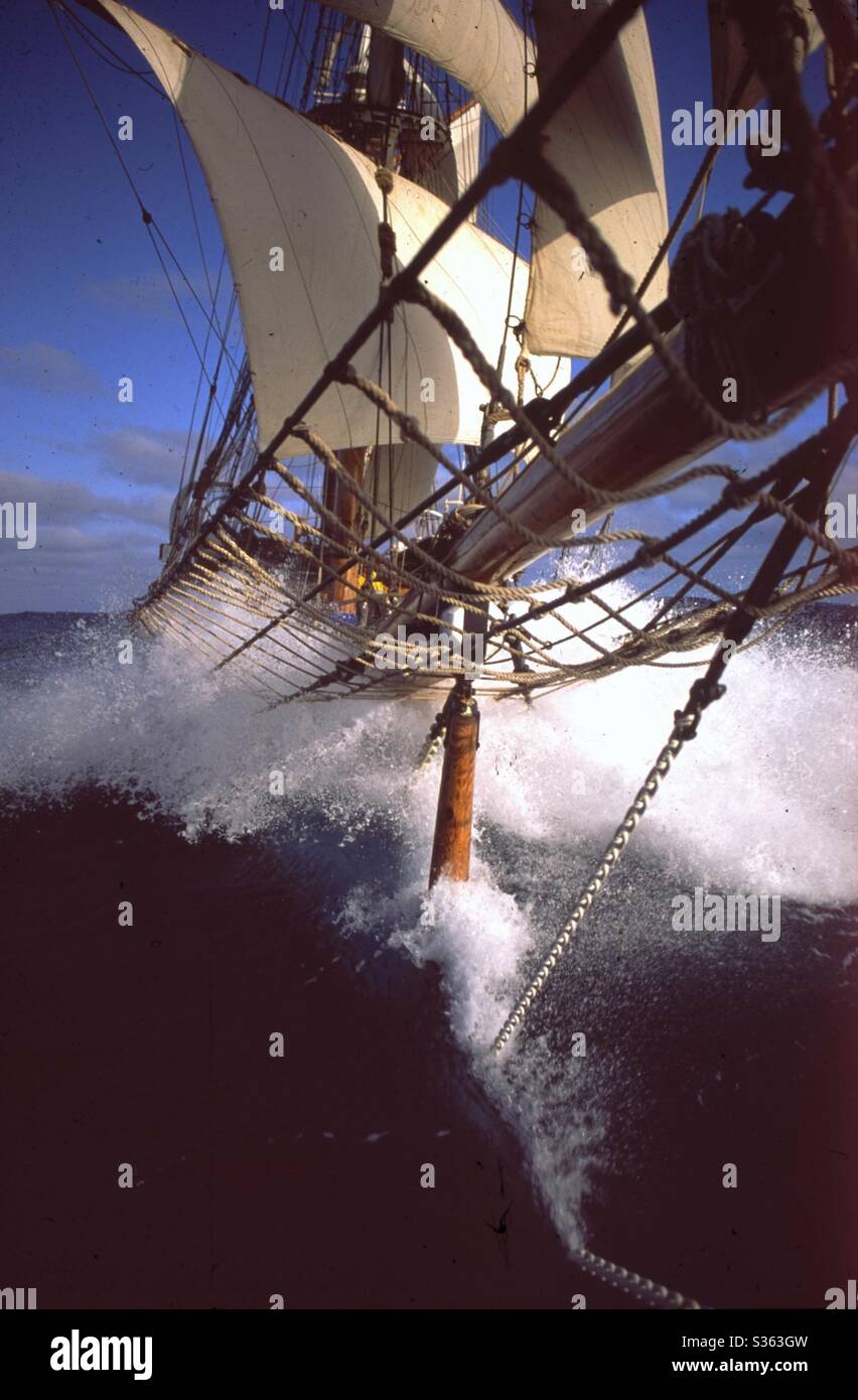 Vieux navire à grande hauteur carrée, Soren Larsen, courant dans l'Atlantique Nord avec un vent fort faisant une grande vague d'arc et un jet. Banque D'Images