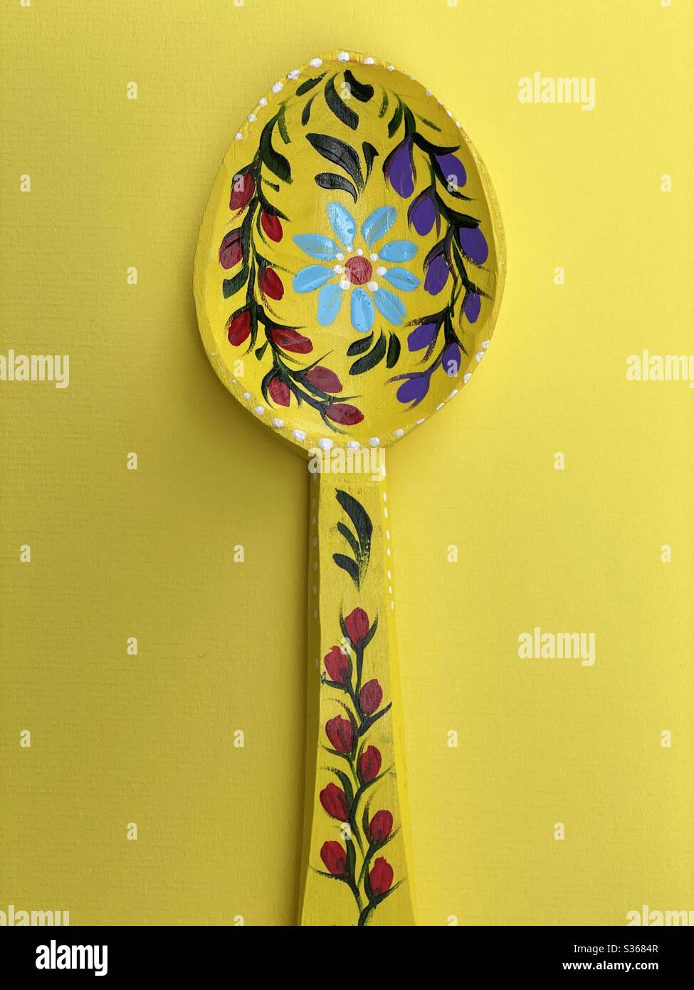 Cuillère en bois décorée sur fond jaune - Image de stock capturée avec un smartphone