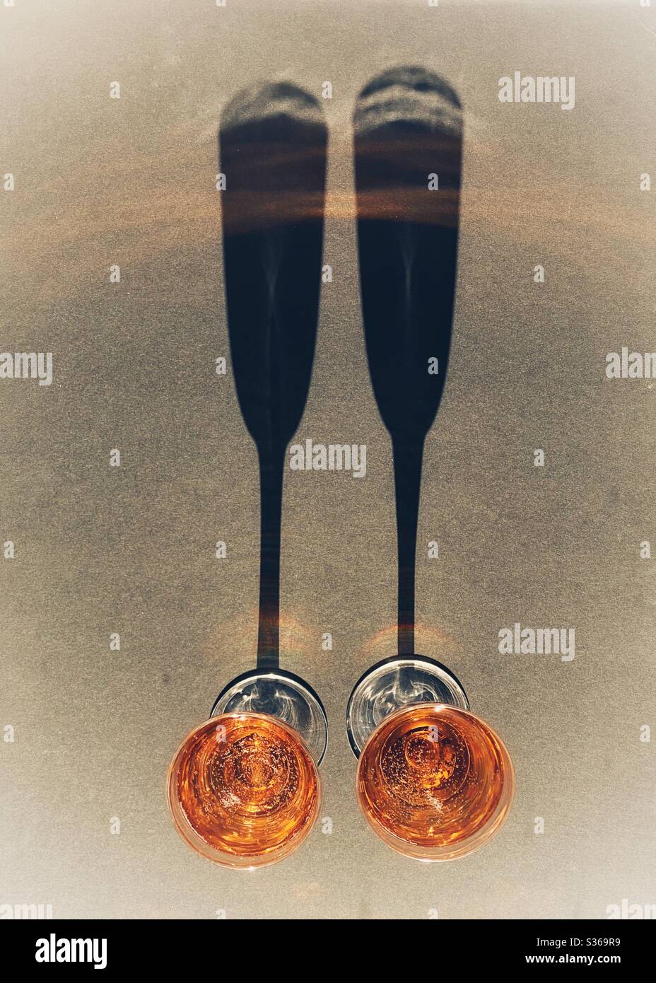 Deux verres de champagne rose avec de longues ombres. Personne. Banque D'Images