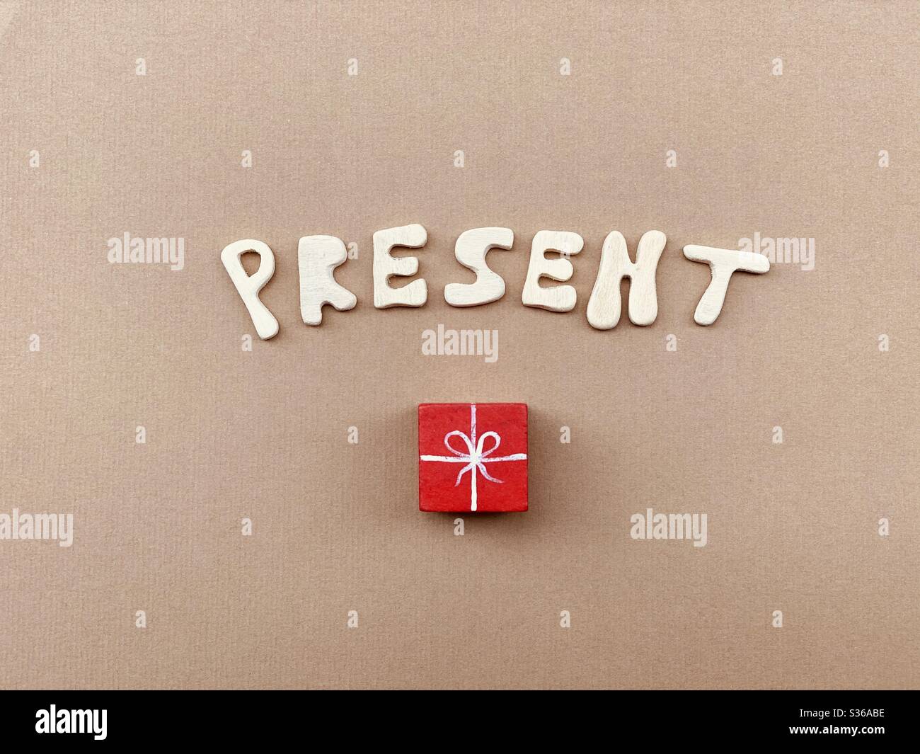 Composition conceptuelle actuelle avec des lettres en bois faites à la main et une parcelle en bois rouge - Image de stock capturée avec un smartphone