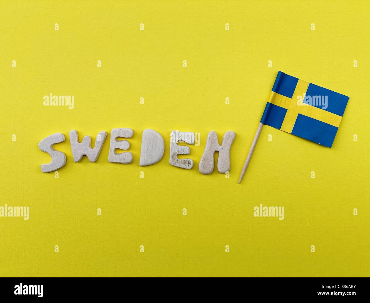 Suède, souvenir composé de lettres en bois faites à la main et d'un drapeau suédois en papier de couleur jaune - Image de stock capturée avec un smartphone