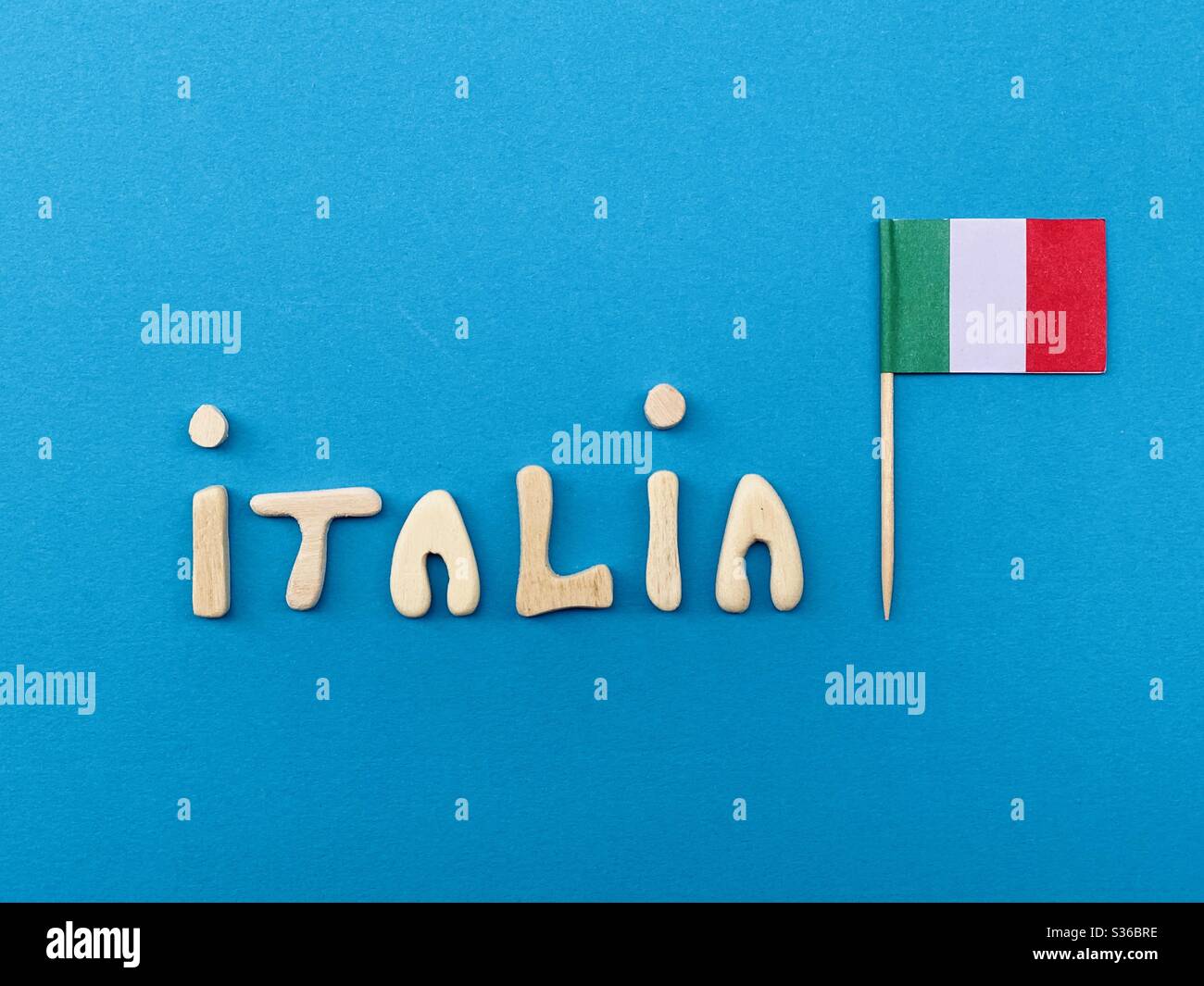 Italia, souvenir composé de lettres en bois faites à la main et drapeau national sur la couleur bleue - Image de stock capturée avec un smartphone