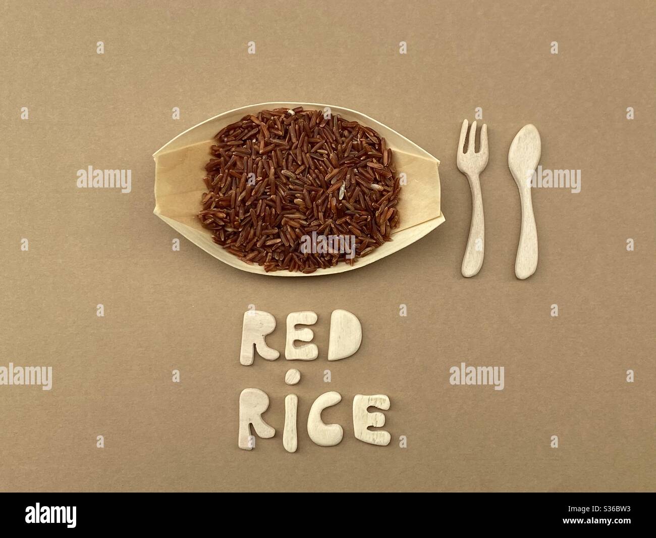 Logo de riz rouge avec composition de lettres et de couverts en bois faits main - Image de stock capturée avec un smartphone