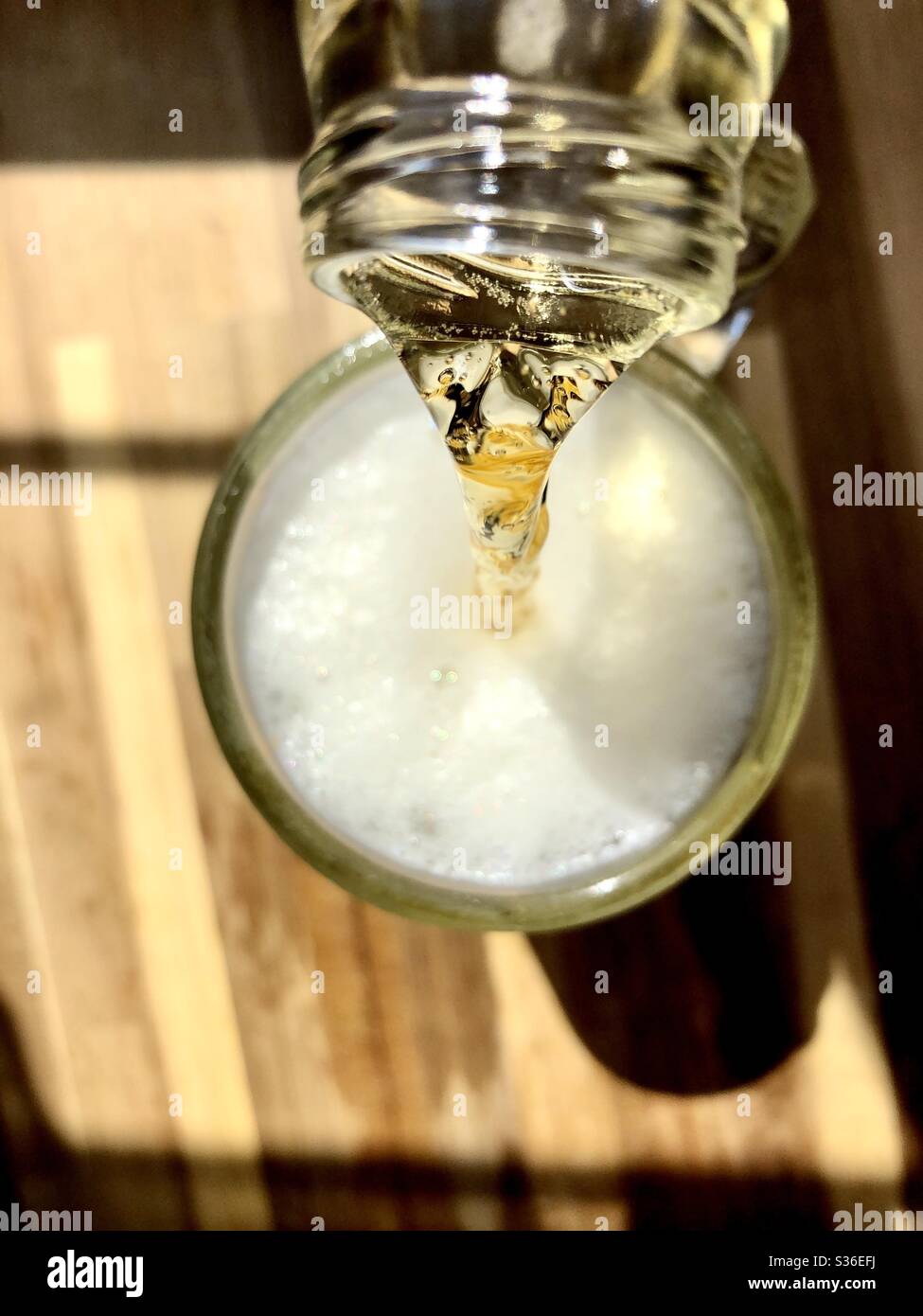 Verser la bière dans un verre transparent Banque D'Images