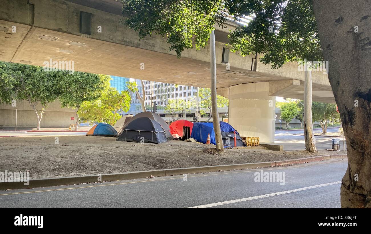 LOS ANGELES, CA, MAI 2020 : campement pour sans-abri à grande vue composé de plusieurs tentes, près des immeubles de bureaux, des appartements et des hôtels, sous un pont supérieur dans le centre-ville. Banque D'Images