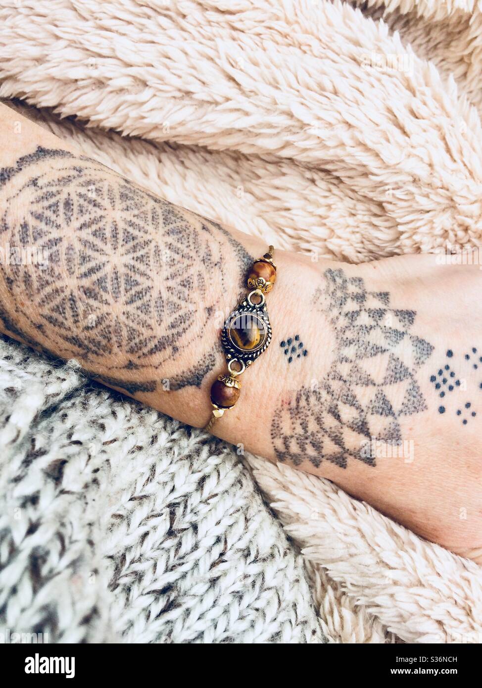 Bracelet sur main féminine avec tatouage Banque D'Images