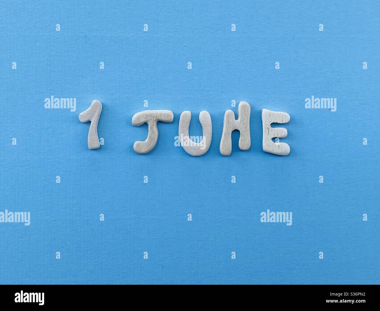 1 juin, date de calendrier composée de lettres en bois faites à la main sur la couleur bleue - Image de stock capturée avec un smartphone