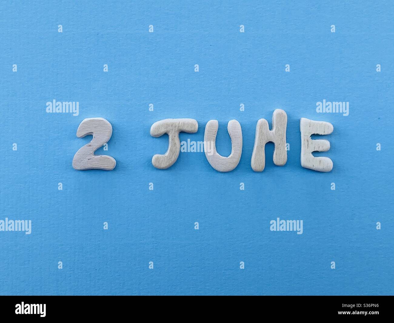 2 juin, date de calendrier composée de lettres en bois faites à la main sur la couleur bleue - Image de stock capturée avec un smartphone