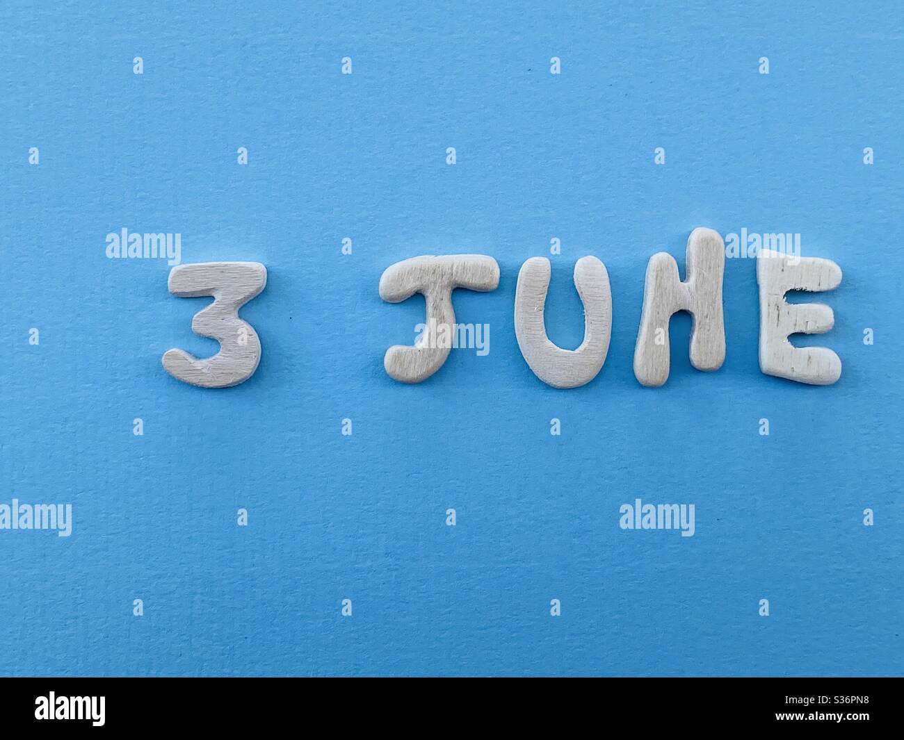 3 juin, date de calendrier composée de lettres en bois faites à la main sur la couleur bleue - Image de stock capturée avec un smartphone