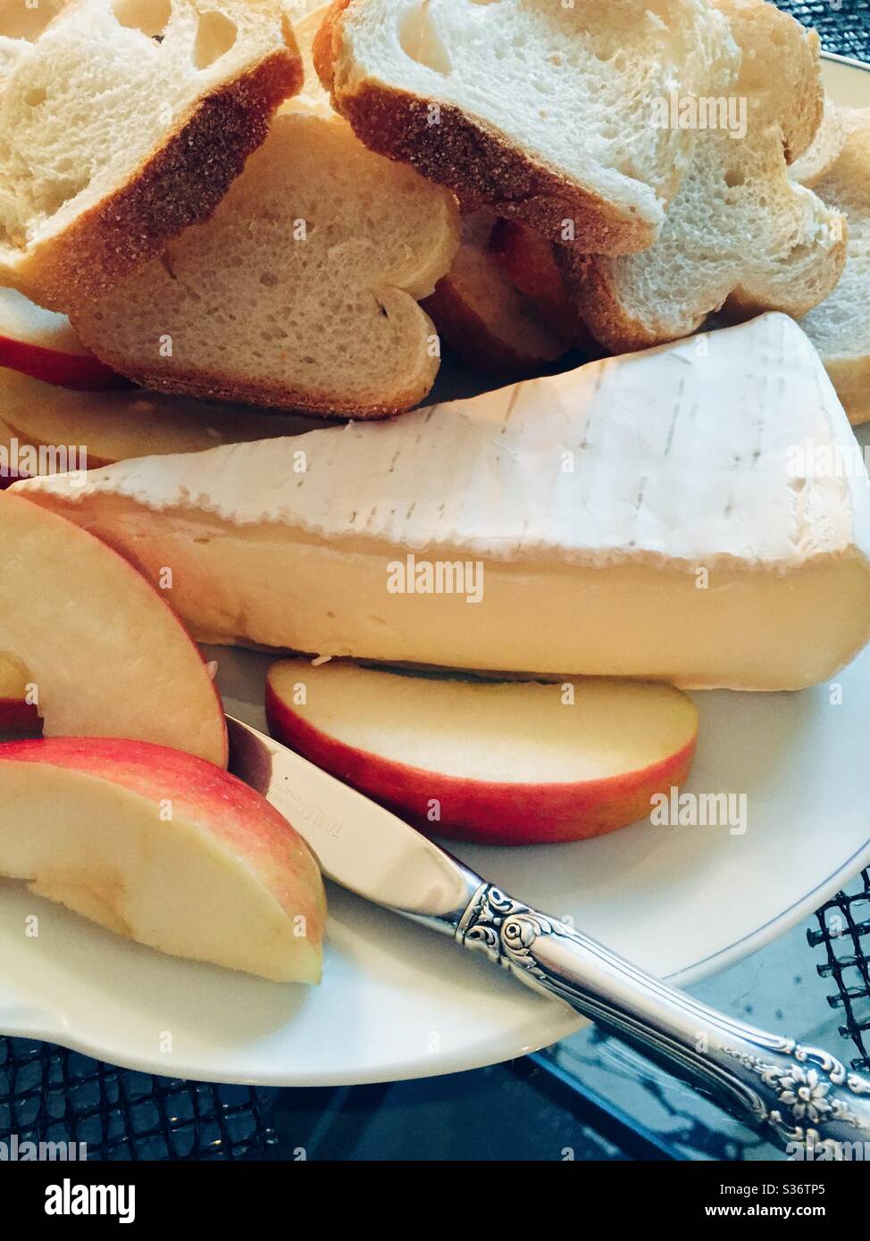 Gros plan d'une cale de brie avec une baguette en tranches et des morceaux de pomme fraîche - Image de stock capturée avec un smartphone