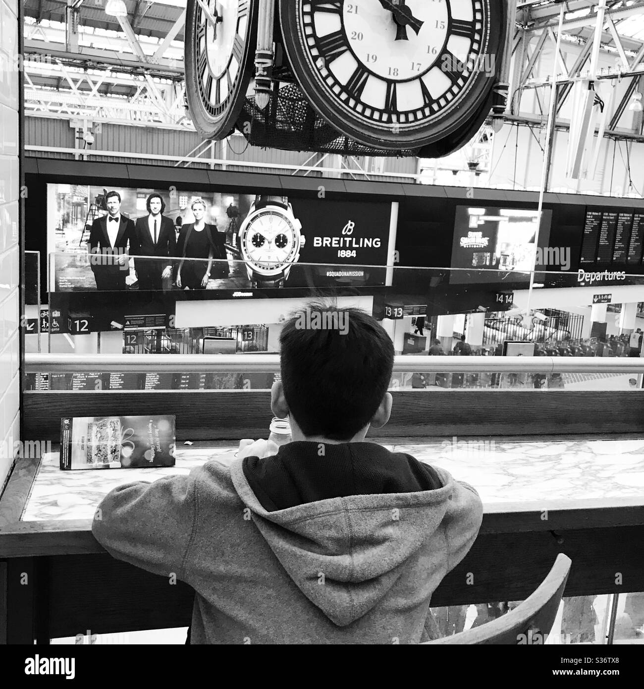 Garçon dans un café qui regarde de l'autre côté de la gare de Waterloo Banque D'Images