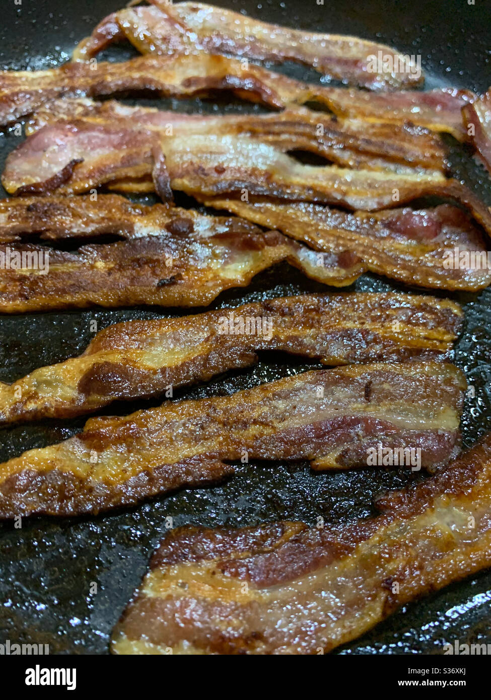 Bacon croustillant de style américain pour le petit déjeuner. Bacon et œufs. Bacon strié. Aliments gras. Banque D'Images