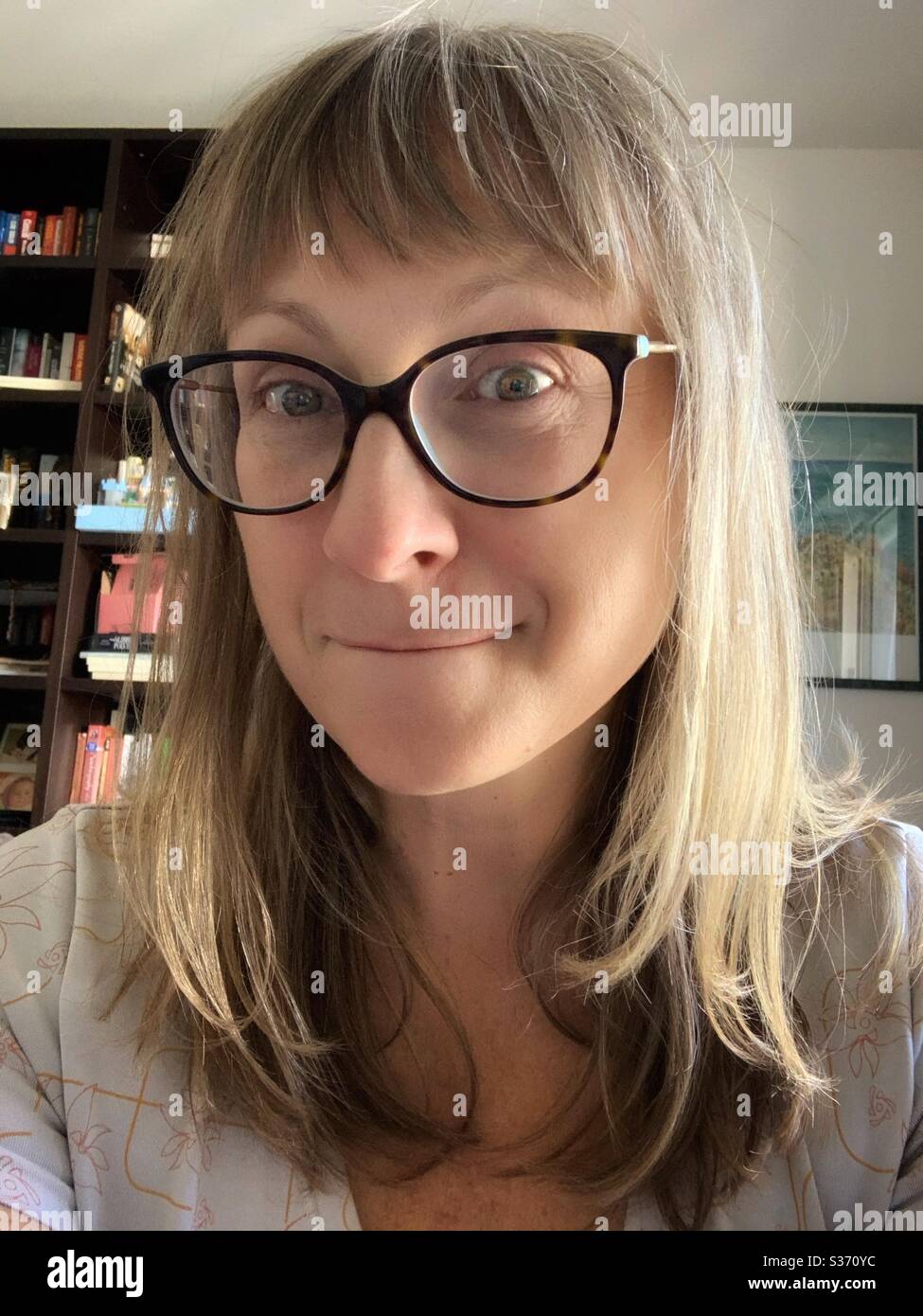Portrait de femme blonde avec des lunettes faisant un visage stupide. Banque D'Images