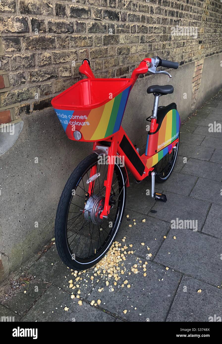 SAUTEZ EN VÉLO en vous appuyant contre un mur de briques à Londres décoré avec le drapeau LGBT pour célébrer la fierté - Image de stock capturée avec un smartphone