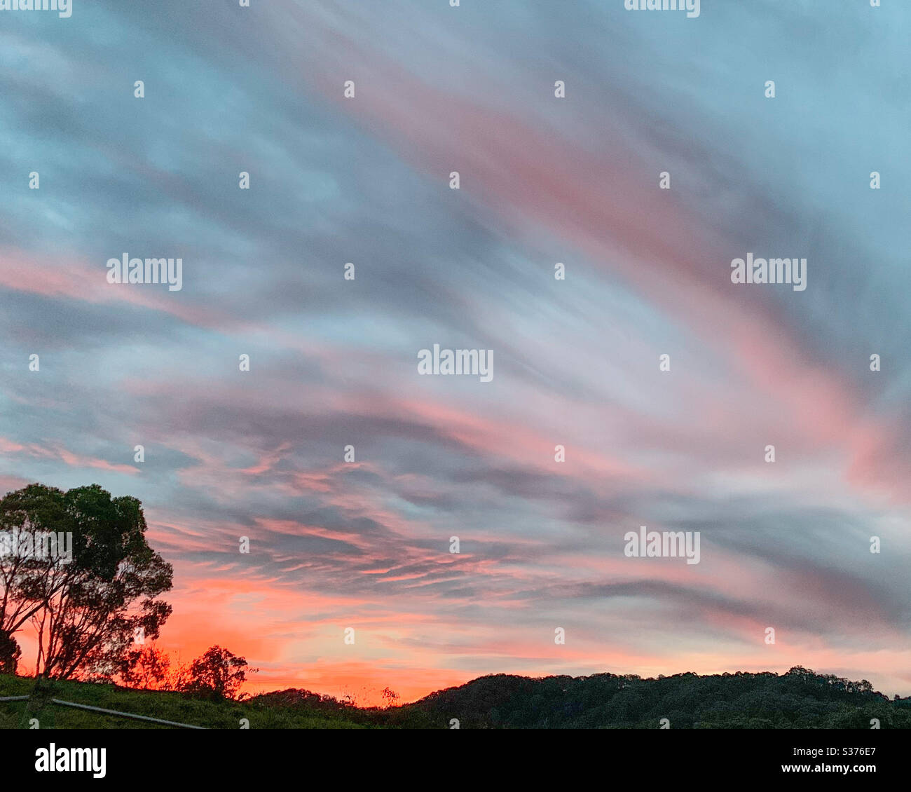 De magnifiques tons de rose orange et de gris dans les nuages ce majestueux coucher de soleil d'hiver Banque D'Images