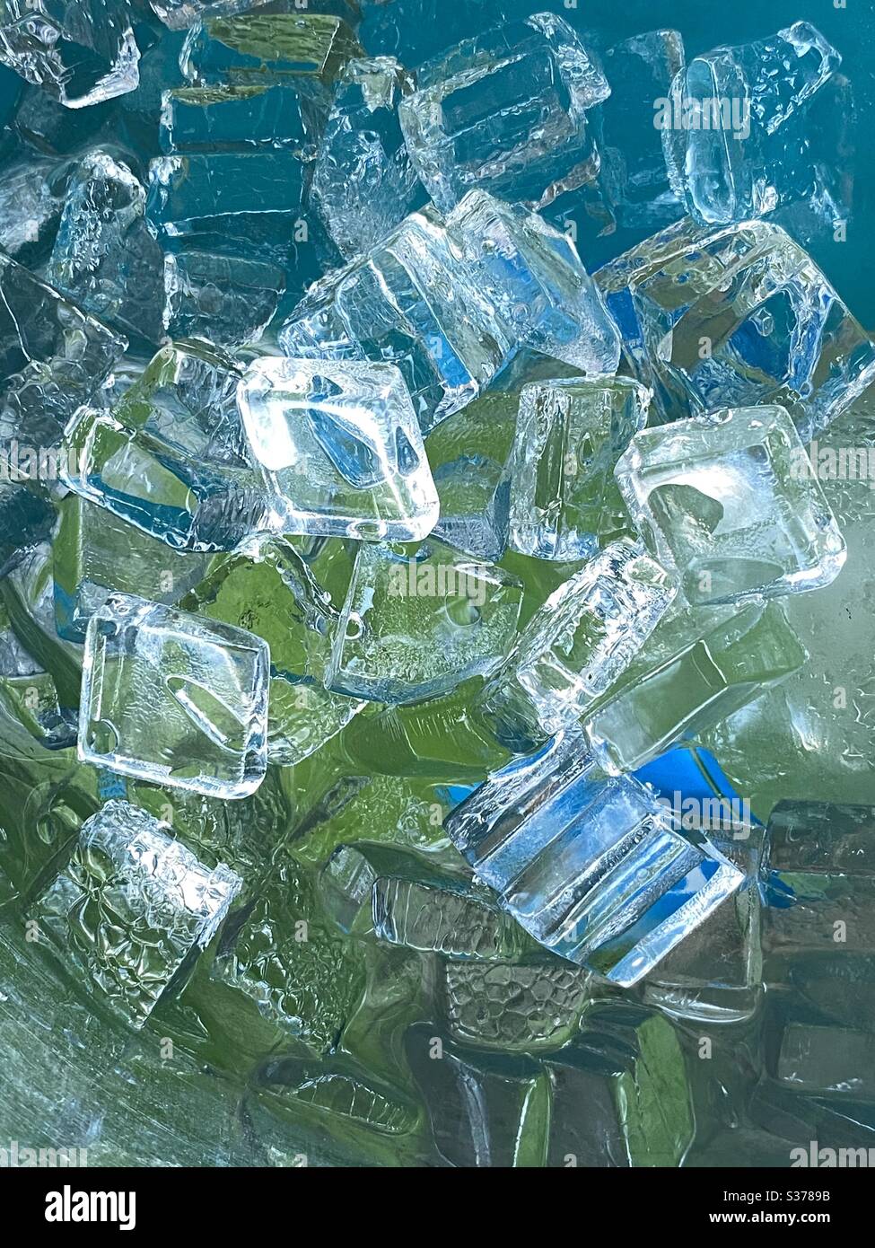 Arrière-plan abstrait des cubes de glace reflétant les couleurs bleu et vert Banque D'Images