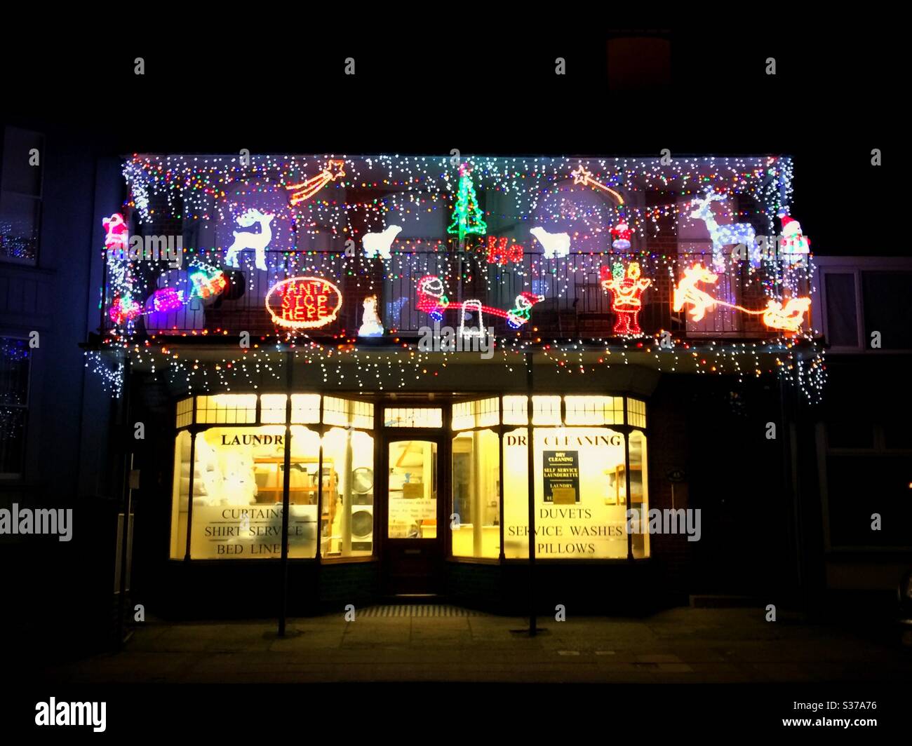 Lumières et décorations de Noël sur un nettoyage à sec et une blanchisserie à Walmer, Deal, Kent, Royaume-Uni Banque D'Images