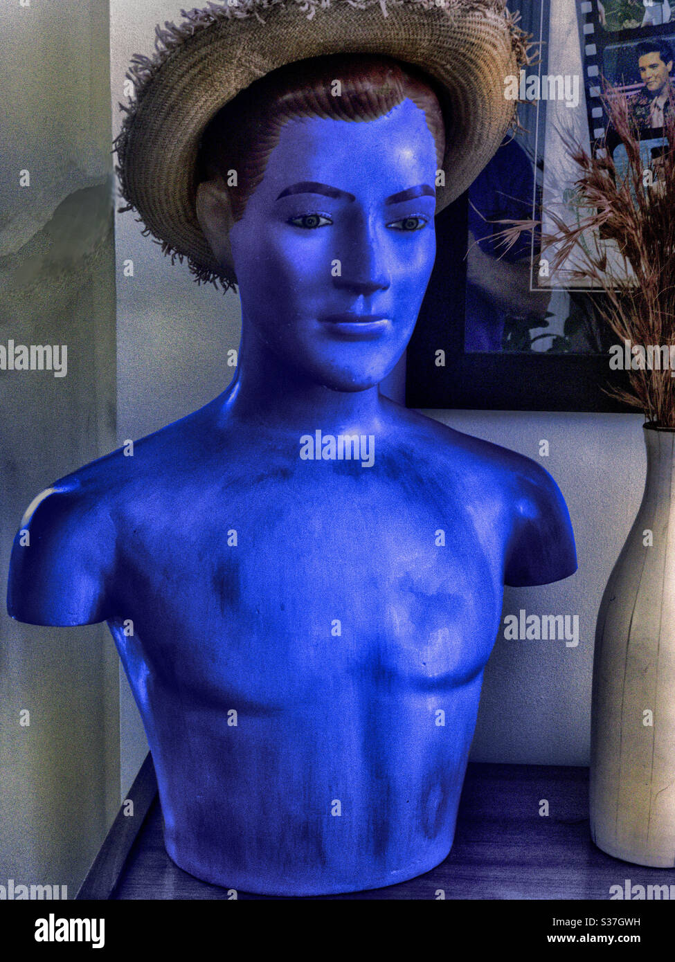 Statue bleue. Concept de vacances à Blue Hawaii avec statue de couleur appropriée contre une affiche du film Elvis Presley du même nom Banque D'Images