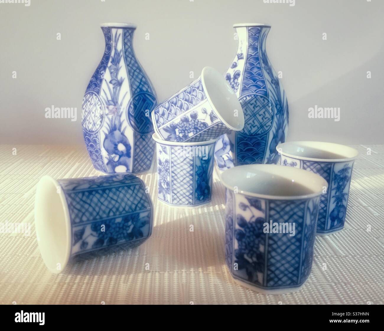 Ensemble de service de saké de deux bouteilles et 5 tasses sur fond blanc - Image de stock capturée avec un smartphone