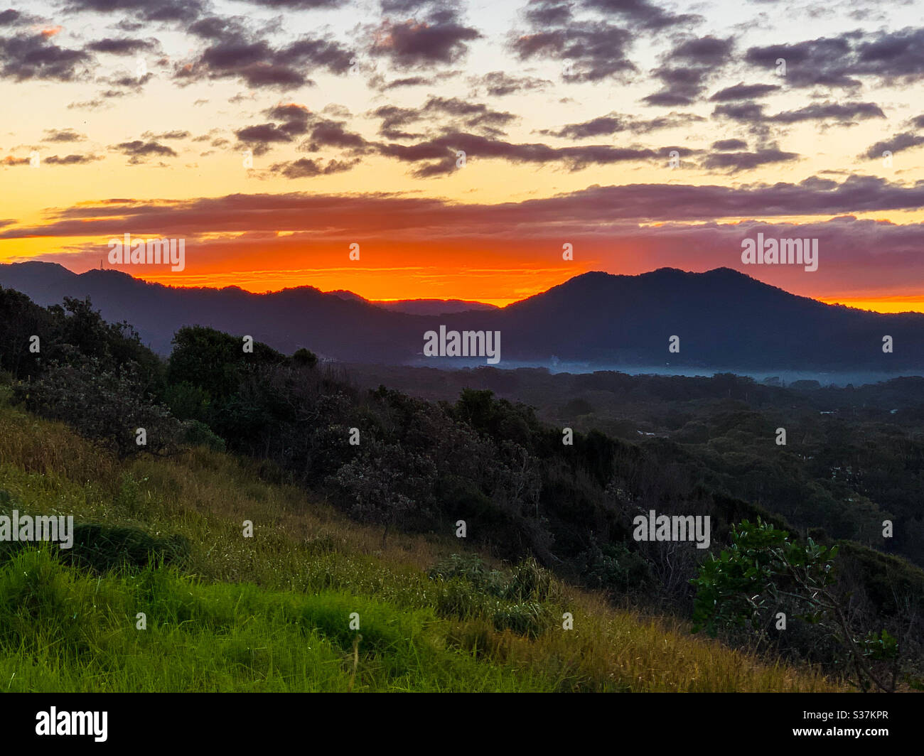 Coucher de soleil spectaculaire, ciel en feu comme couchers de soleil derrière les collines. Majestic, un kaléidoscope de couleurs éclatant avec la dernière lumière du soleil, l'hiver, l'Australie Banque D'Images