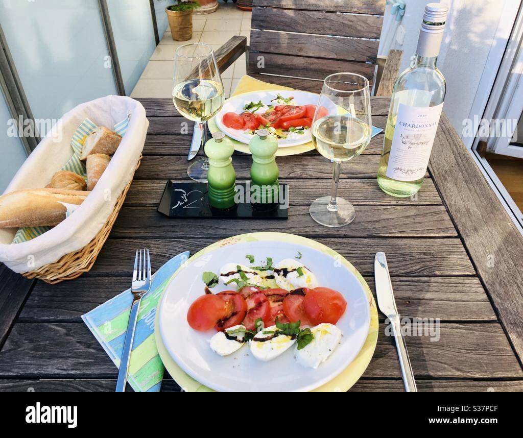 Table de dîner pour deux avec mozzarella et tomates, vin blanc sur le balcon Banque D'Images