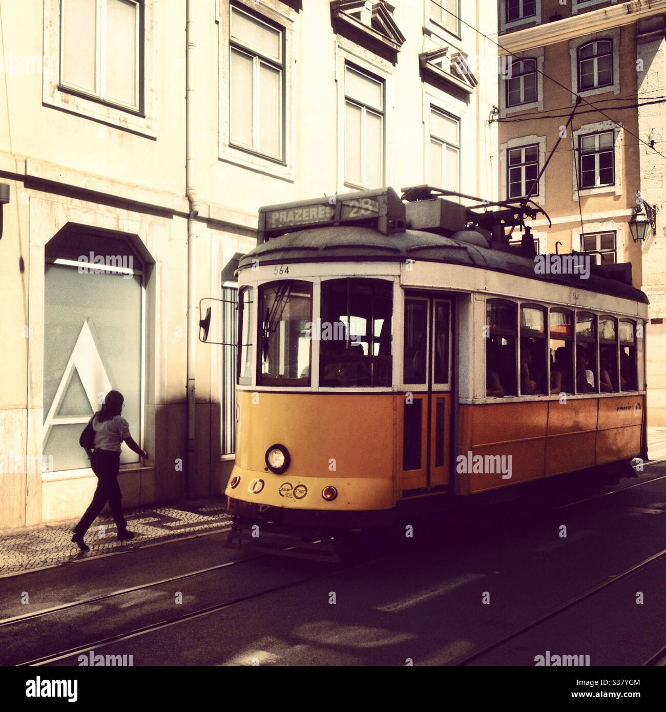 Une femme marche à Lisbonne, au Portugal, a passé un tramway jaune, Banque D'Images