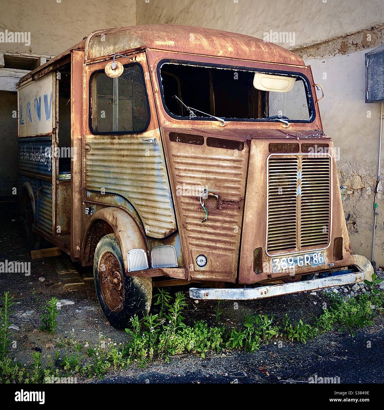 Une fourgonnette de type H rouillée abandonnée dans une grange française. - Image de stock capturée avec un smartphone