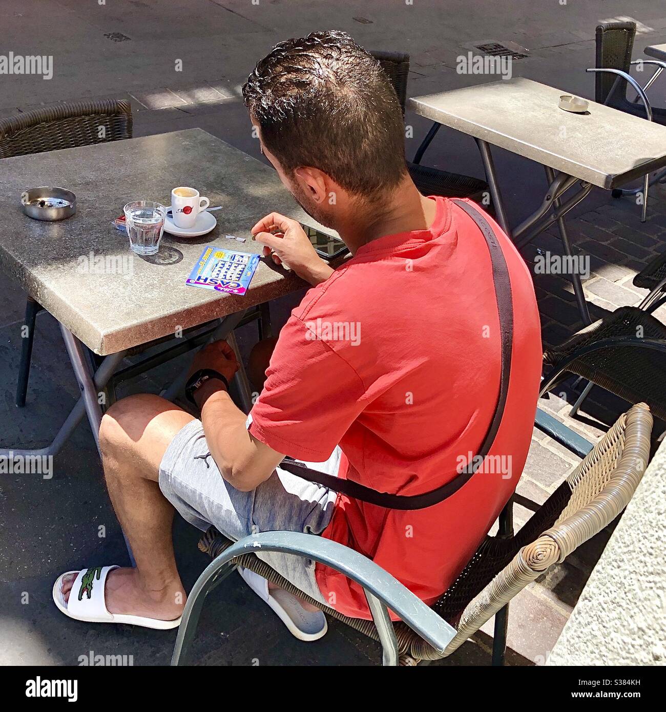 Homme sur la terrasse du café jouant sur la carte mémoire - Tours, France. Banque D'Images