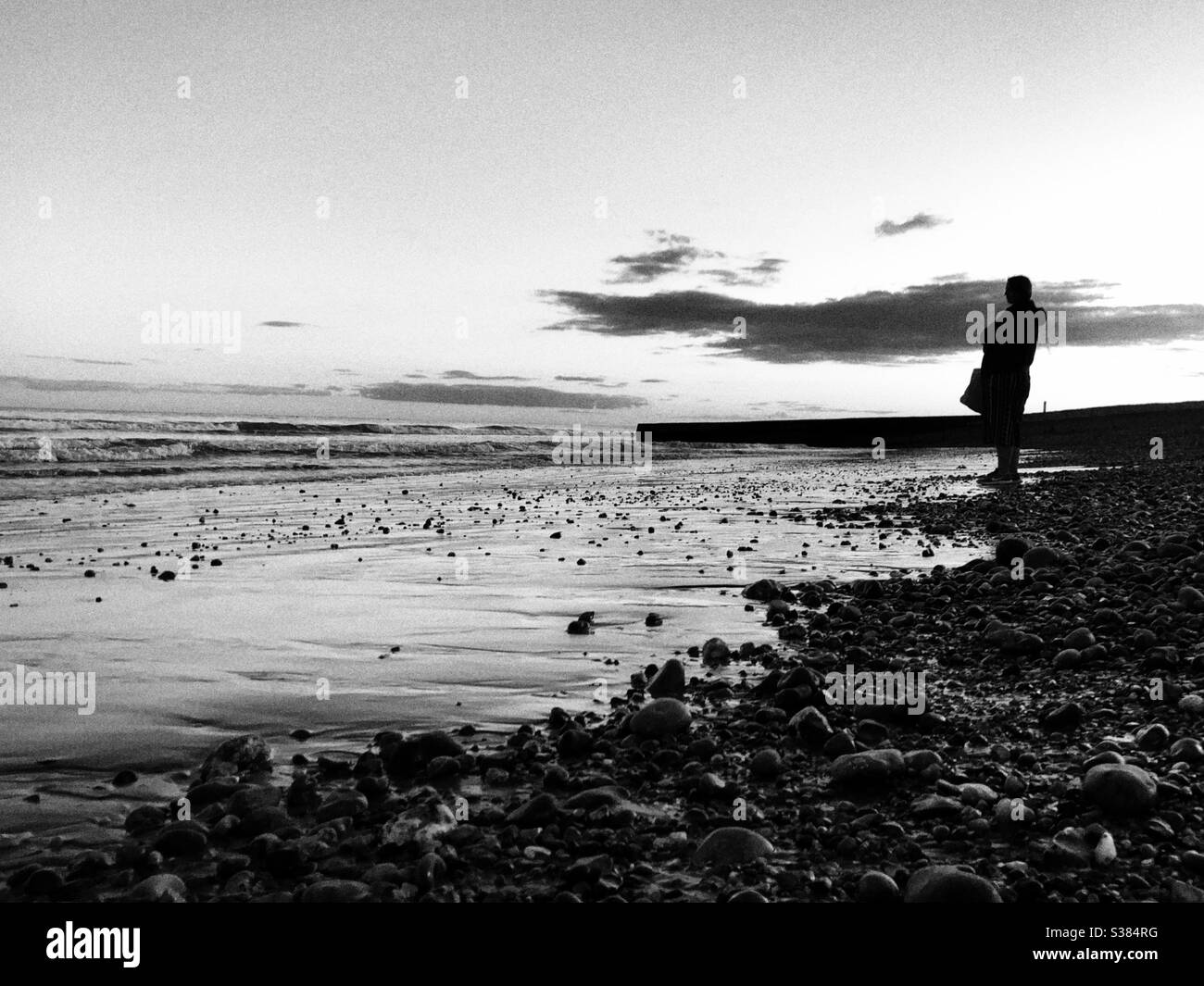 Silhouette d'une personne debout près du rivage qui regarde la mer Banque D'Images