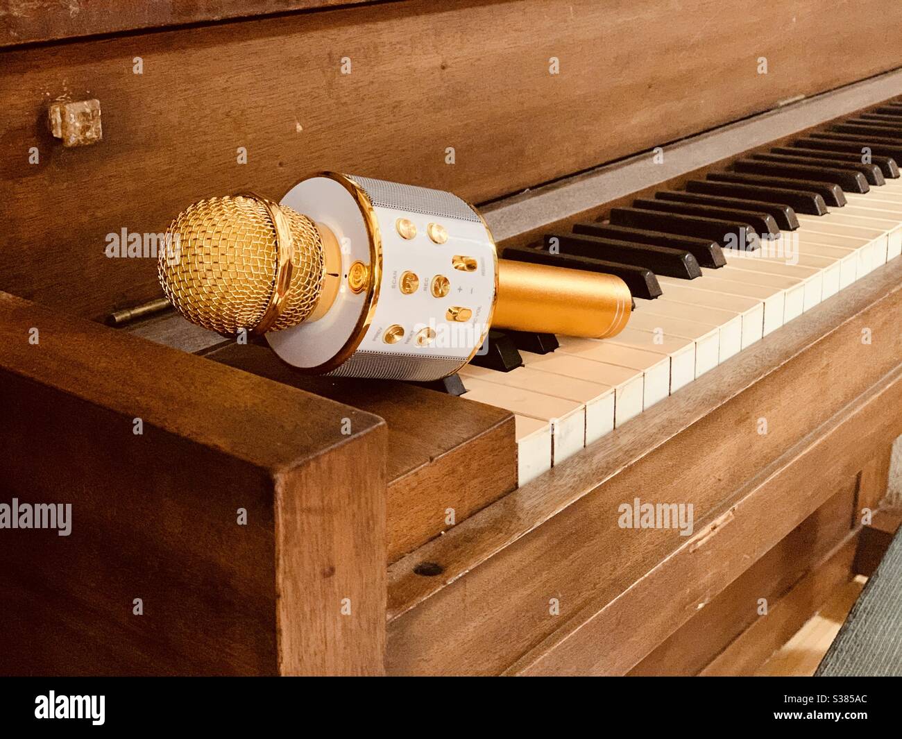 Microphone doré sur piano en bois Banque D'Images