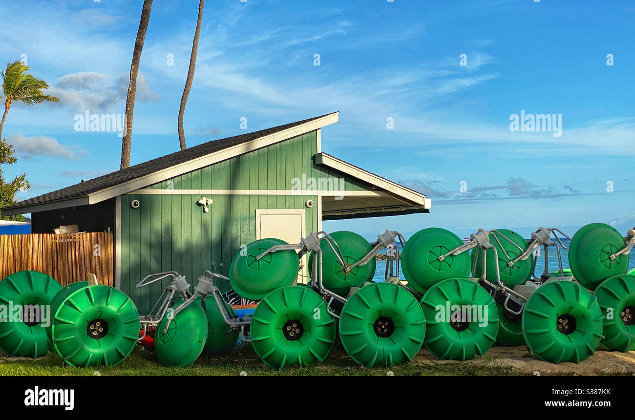 Tricycles d'eau verte empilés le long d'un hangar vert - Image de stock capturée avec un smartphone