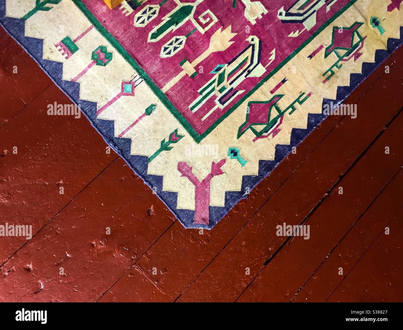 Un vieux tapis à tissage plat sur un vieux plancher en bois, Canada - Image de stock capturée avec un smartphone
