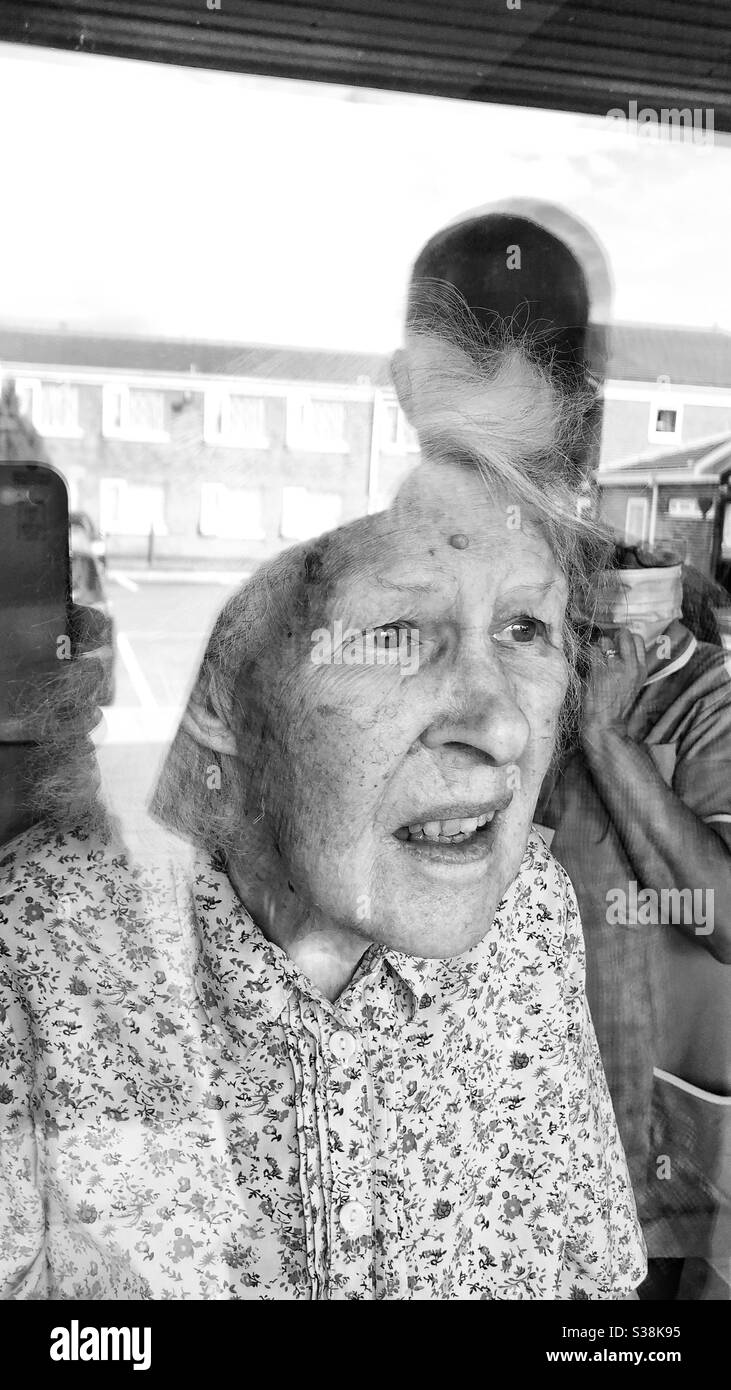 La vieille dame qui se trouve dans la maison de soins est visitée par la famille pendant covid19 Banque D'Images