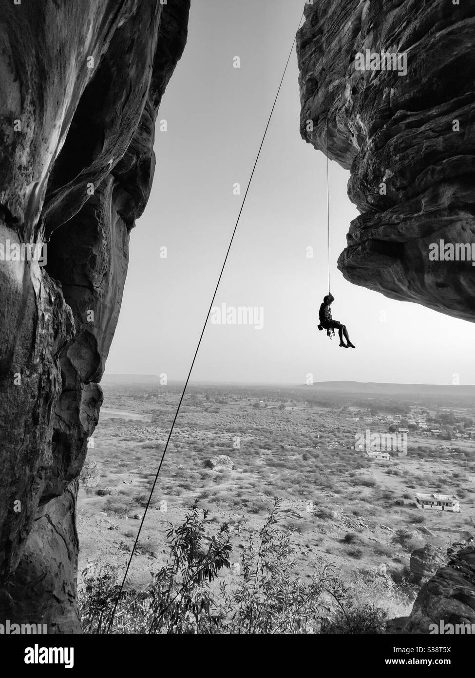 Un grimpeur accroché à la corde en descendant après avoir grimpé sur le rocher de granit près de Badami, Karnataka, Inde Banque D'Images