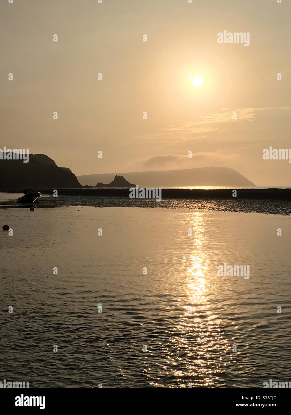 Coucher de soleil brumeux sur la mer ondulée Banque D'Images