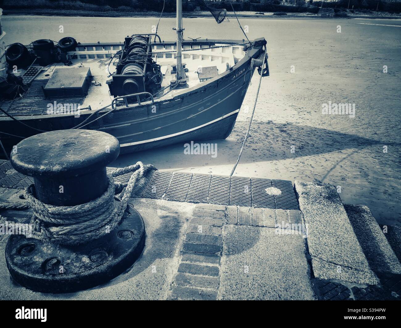 Un ancien chalutier, ancré dans un port sablonneux, avec son bollard d'amarrage, au sud du pays de Galles. Banque D'Images