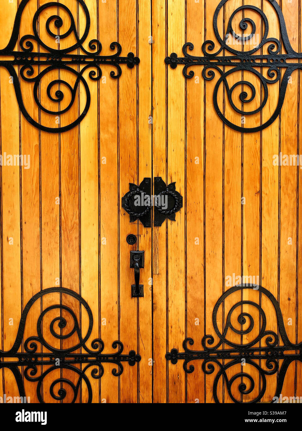 Portes d'entrée en bois avec ferronnerie noire ornée Banque D'Images