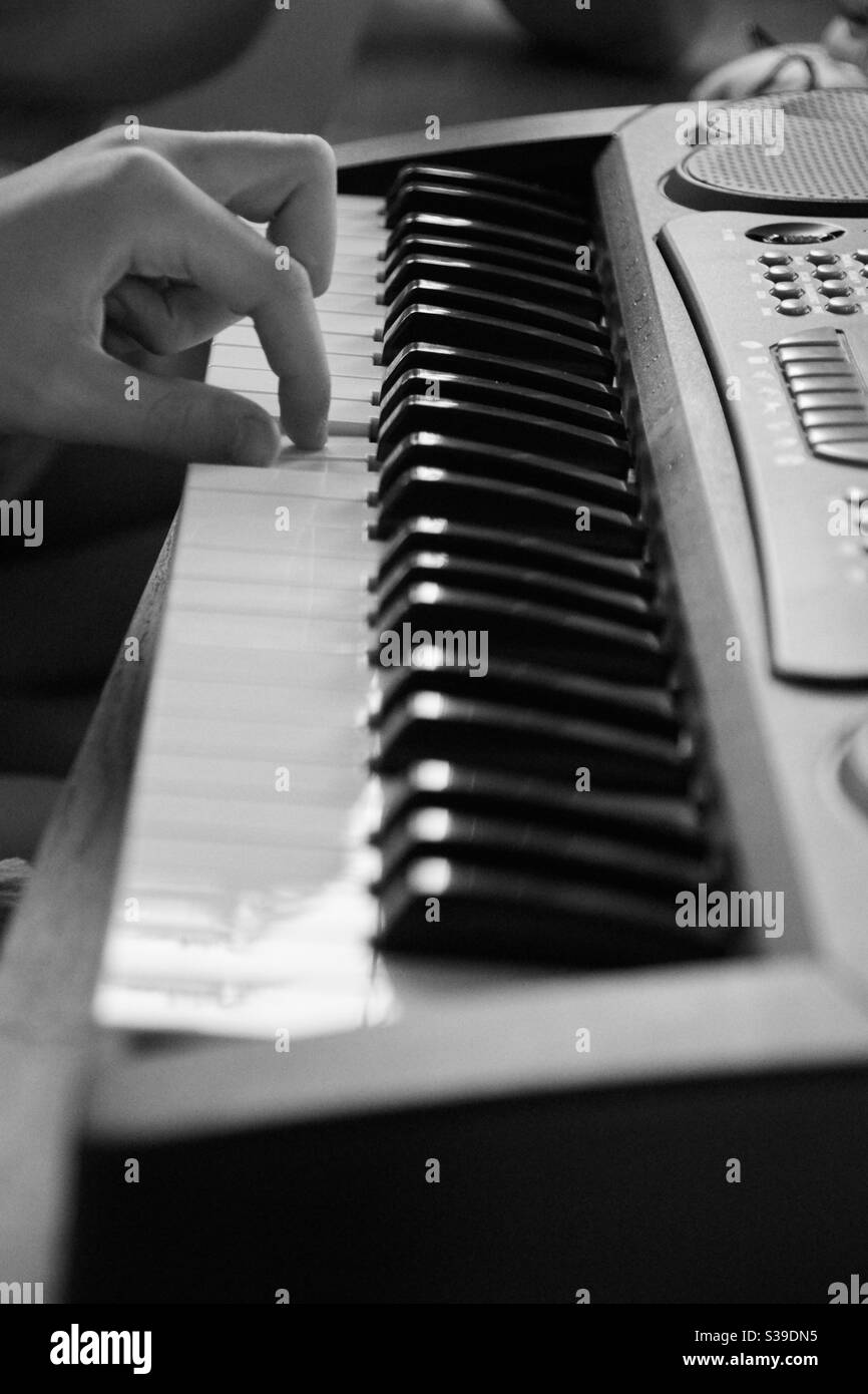 Doigts une main tapant sur un piano électronique, noir et blanc, debout Banque D'Images
