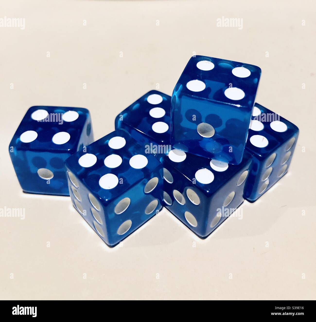 Six dés bleus avec points blancs sur fond beige clair - Image de stock capturée avec un smartphone