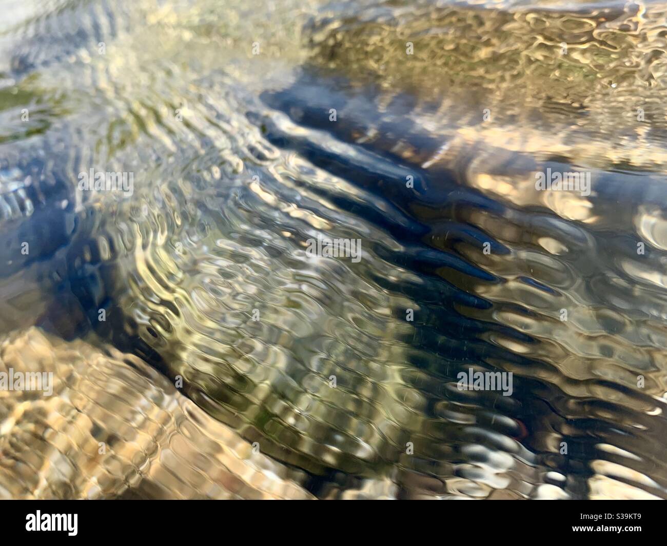 Des ondulations d'eau s'écoulant sur des pierres dans une rivière - Image de stock capturée avec un smartphone